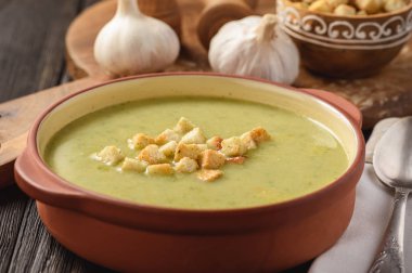 Ahşap arka plan üzerinde croutons kremalı brokoli çorbası.
