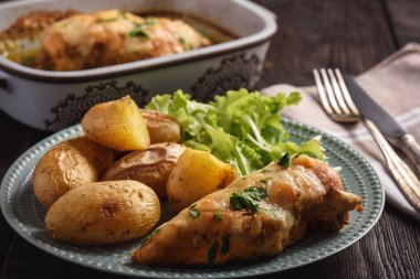 Tavuk fileto mozzarella ve sarımsak tereyağı ile pişmiş. Kavrulmuş patates ile hizmet.