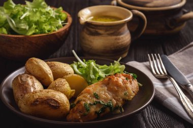 Tavuk fileto mozzarella ve sarımsak tereyağı ile pişmiş. Kavrulmuş patates ile hizmet.