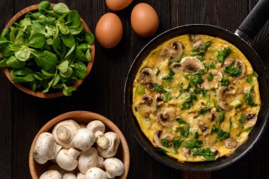 Mantar ve koyu ahşap arka plan üzerine peynir omlet.