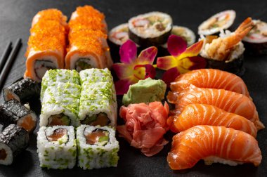 Siyah taş zemin üzerine mix sushi seti.