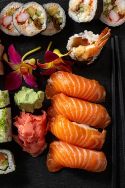 Siyah taş zemin üzerine mix sushi seti.