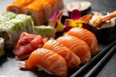 Siyah taş zemin üzerine mix sushi seti.