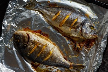 Limon, koyu arka plan üzerinde fırında çipura.