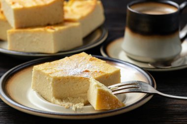 Ev yapımı dilimlenmiş cheesecake ve kahve fincan. 