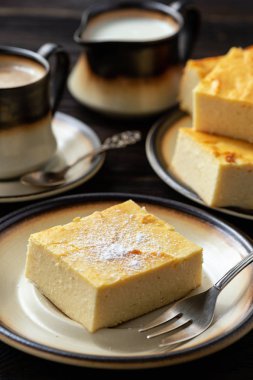 Ev yapımı dilimlenmiş cheesecake ve kahve fincan. 