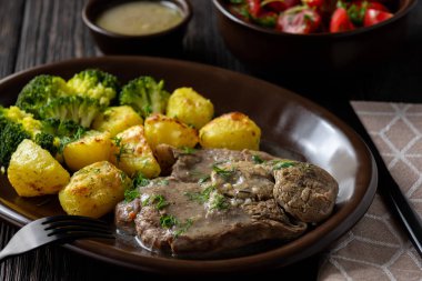 Kavrulmuş patates ve brokoli ile kuzu Yavaş kızartma bacak.