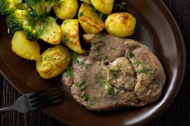 Kavrulmuş patates ve brokoli ile kuzu Yavaş kızartma bacak.