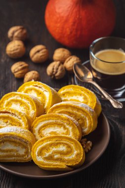 Koyu ahşap arka planda kremalı balkabaklı kek..