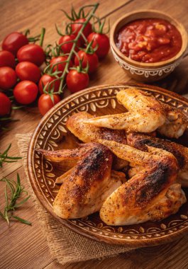 Fırın kavrulmuş tavuk kanadı domates sos ile.