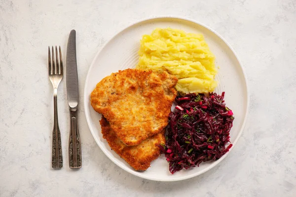 Chop pork cutlets , served with mashed potatoes and beetroot salad.