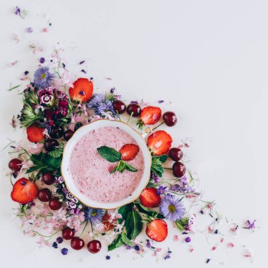 kiraz ve beyaz arka plan üzerinde çiçekler ile çilek çorbası üzerinde üstten görünüm 