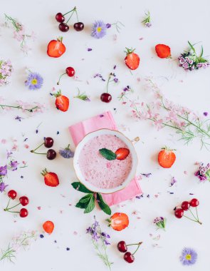 kiraz ve beyaz arka plan üzerinde çiçekler ile çilek çorbası üzerinde üstten görünüm 