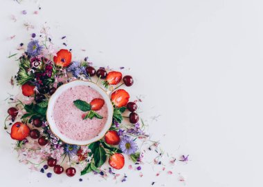 kiraz ve beyaz arka plan üzerinde çiçekler ile çilek çorbası üzerinde üstten görünüm 