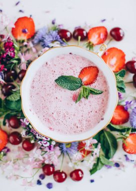 kiraz ve beyaz arka plan üzerinde çiçekler ile çilek çorbası üzerinde üstten görünüm 