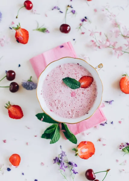 kiraz ve beyaz arka plan üzerinde çiçekler ile çilek çorbası üzerinde üstten görünüm 