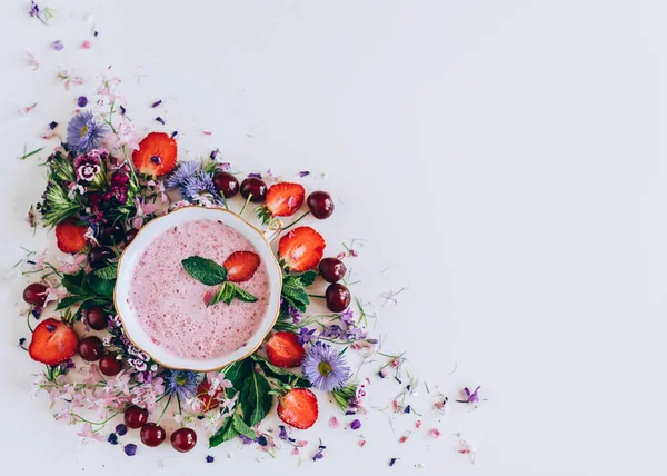 kiraz ve beyaz arka plan üzerinde çiçekler ile çilek çorbası üzerinde üstten görünüm 