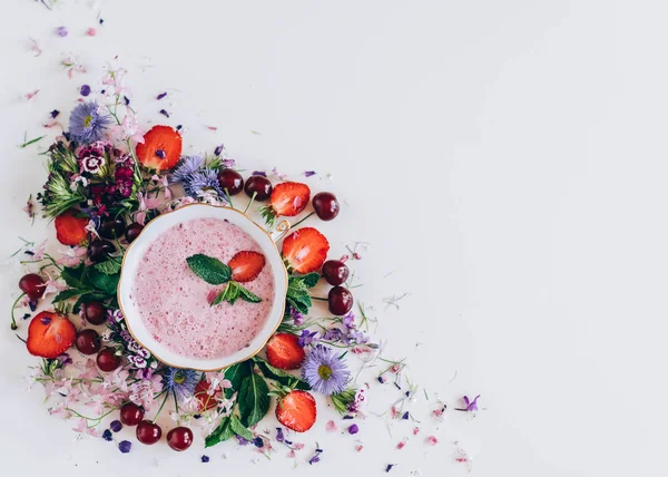 kiraz ve beyaz arka plan üzerinde çiçekler ile çilek çorbası üzerinde üstten görünüm 