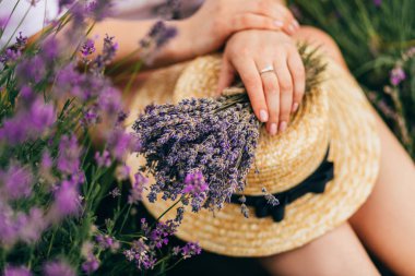 Hasır şapka ve lavanta buket tutan eller