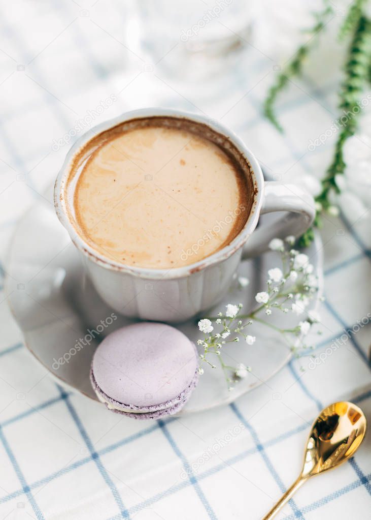 Cup of coffee with milk and macaroon 