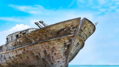 Mavi gökyüzü altında eski bir ahşap balıkçı teknesi