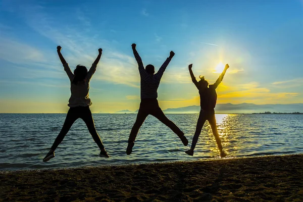 Silhouet Groep Vrienden Plezier Springt Zonsondergang Strand — Stockfoto