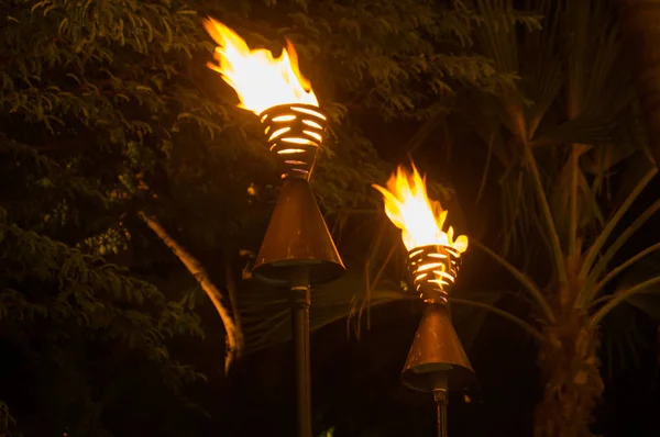 Polynesian torches lit at night in Waikiki