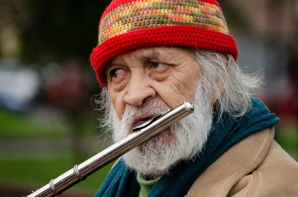 Başkan Tocando la flauta en un parque de Lima.