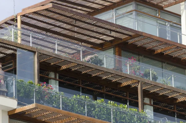 Balcones con acabados de madera y plantas.