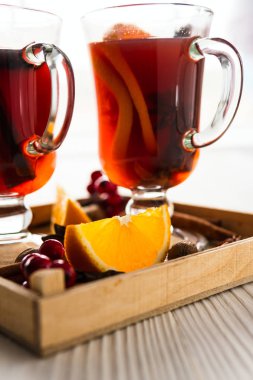 Baharatlar ve ahşap masa üzerinde sıcak mulled şarap bardağı 