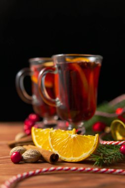 Bardak sıcak baharatlı mulled şarap ve koyu arka plan üzerinde ahşap masa üzerinde Noel için hazırlanan süsleri