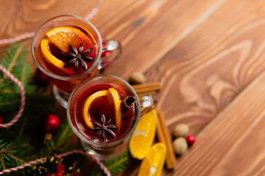 İki bardak sıcak mulled şarap ahşap masa üzerinde farklı baharatlar ile yukarıda