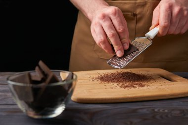 Çikolata kahverengi bir önlük rende ile bir erkekte biler