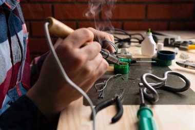 Elektronik onarım ve lehimleme telleri masada özel araç ile bir adam kırpma yan görünüm