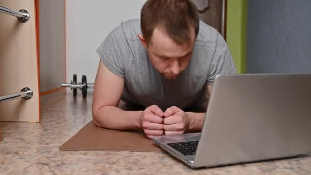 Jongeman doet thuis aan plank oefeningen. Nieuw normaal. — Stockvideo