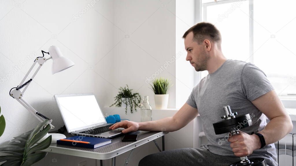 Virtual workout, Fitness at home. Athletic man watching an online video on laptop.