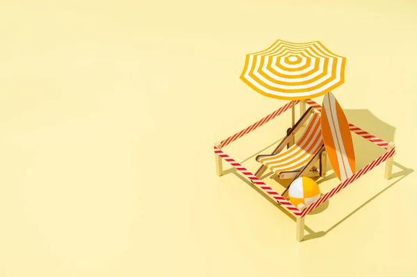 Cadeira de convés com guarda-chuva, prancha e bola na praia. Um local de férias isolado em um resort . — Fotografia de Stock