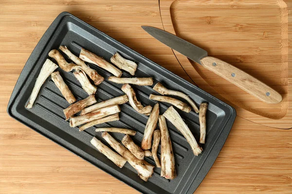 A healthy alternative to coffee. Dried chicory roots on a baking sheet. — Stock Photo, Image