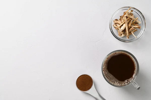 Minuman sehat, alternatif kopi. Chicory minum dalam gelas, akar kering dan bubuk. Latar belakang batu abu-abu muda. — Stok Foto
