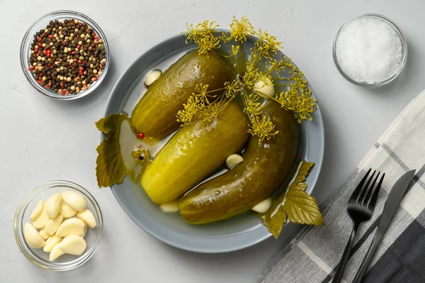 Gezond gefermenteerd voedsel. Gefermenteerde komkommers in een bord op een lichtgrijze ondergrond. — Stockfoto