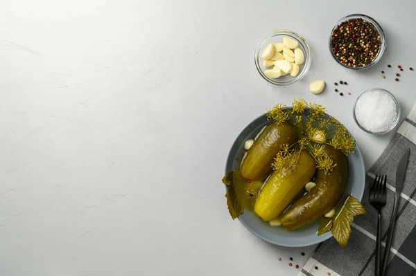 Hälsosam fermenterad mat. Fermenterade gurkor i en platta på en ljusgrå bakgrund. — Stockfoto