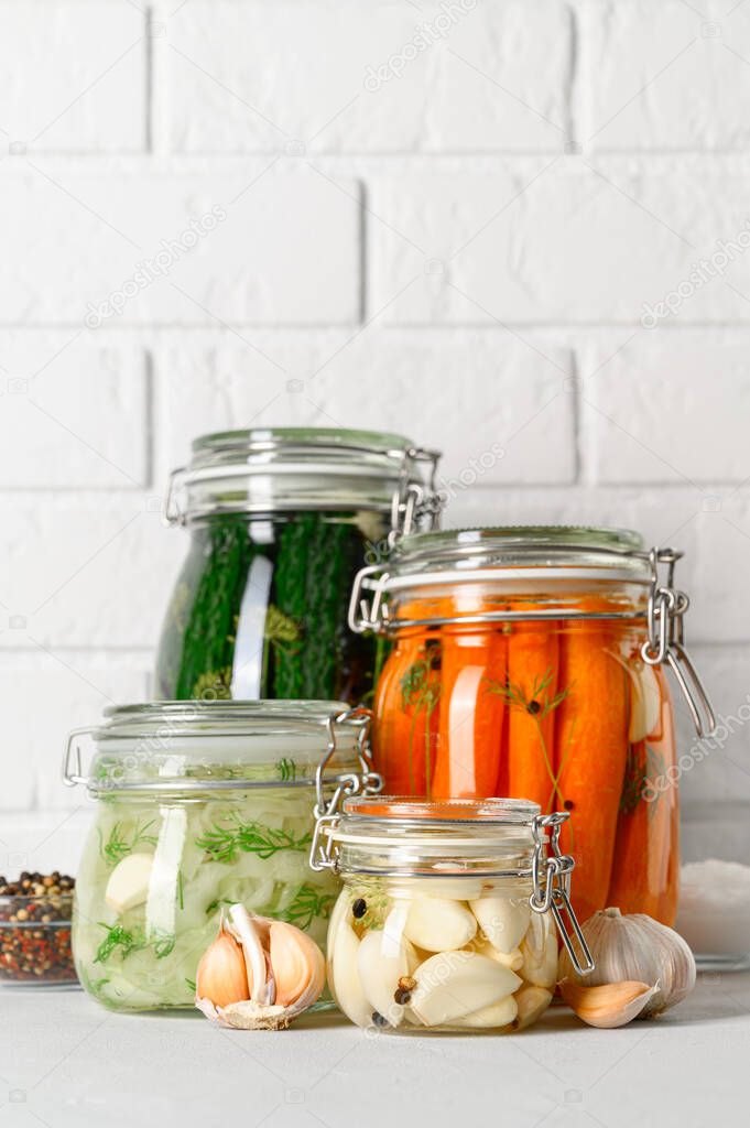 Healthy vegan food. Homemade fermented vegetables cucumbers, carrots, cabbage and garlic in glass jars.