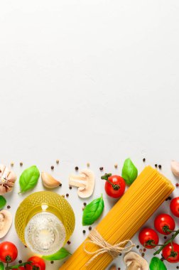 Spagetti ve mantarlı İtalyan makarnası pişirmek için kullanılan malzemeler açık gri arka planda..