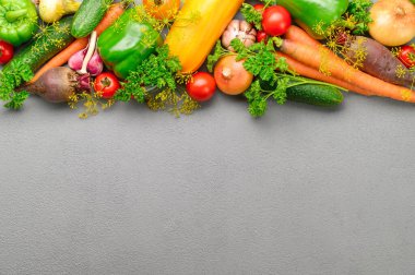 Eko gıda konsepti. Gri arka planda çeşitli taze sebzeler.