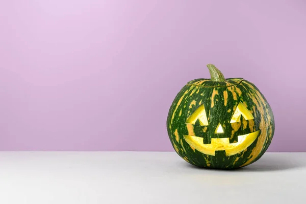 Grappig glimlachen Halloween pompoen op een paarse achtergrond. — Stockfoto