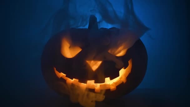 Faccia lucente spaventosa di zucca di Halloween in fumo azzurro. — Video Stock