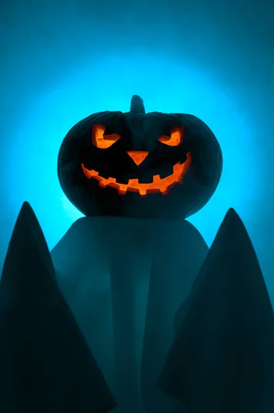 Concepto de Halloween. Un fantasma con una espeluznante cabeza brillante calabaza jack-o-lantern se encuentra en la niebla al atardecer. —  Fotos de Stock