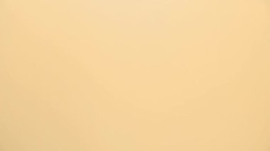 Beyaz bir Cadılar Bayramı balonu sarı arka planda şişer.