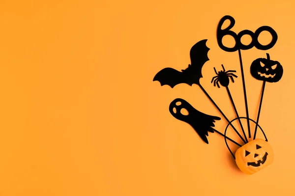 Halloween achtergrond. Top view Halloween party accessoires en Jack-O-lantaarn pompoen op oranje achtergrond. — Stockfoto