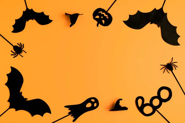 Happy Halloween day. Top view Halloween party accessories on orange background.